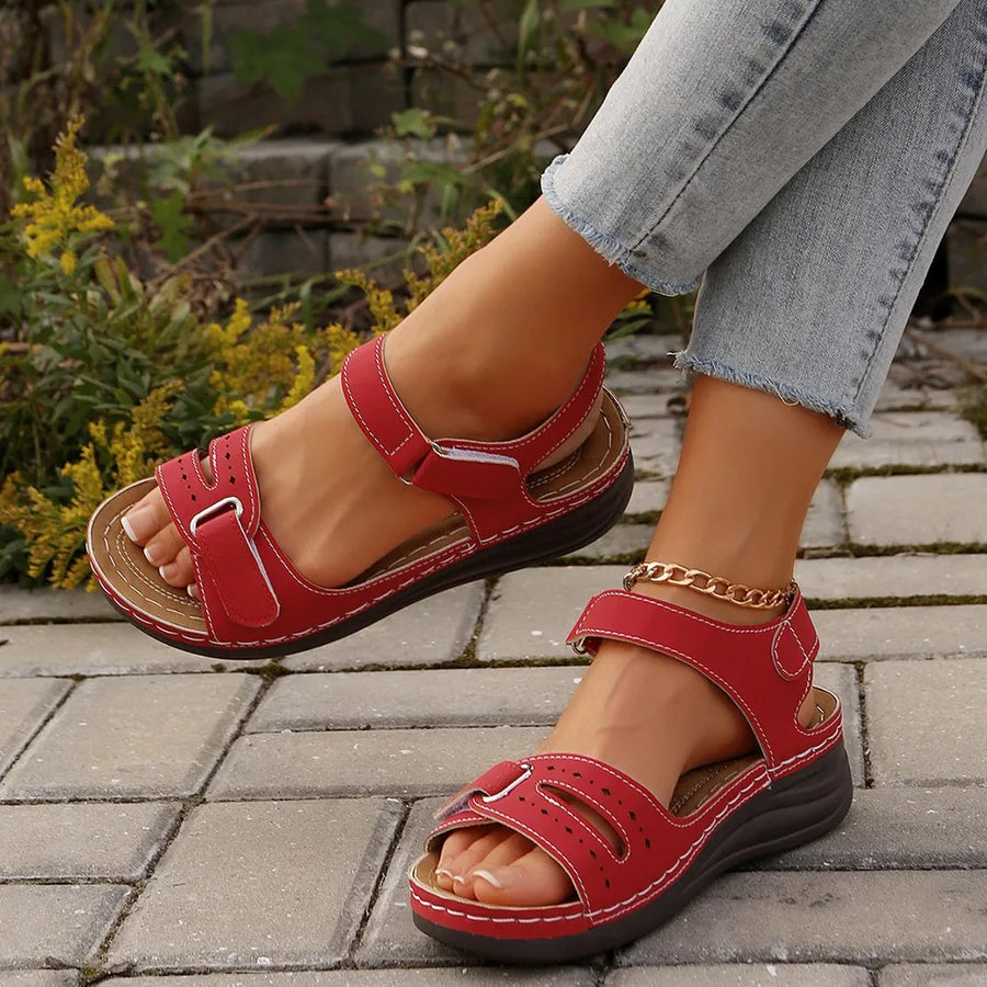 Red perforated detail velcro wedge sandals with adjustable straps and white stitching.