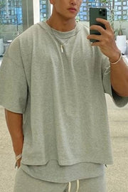 Gray oversized drop-shoulder tee with crew neck and short sleeves.