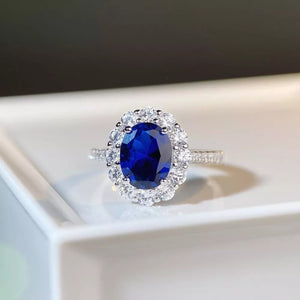 sapphire blue ring featuring halo setting and geometric