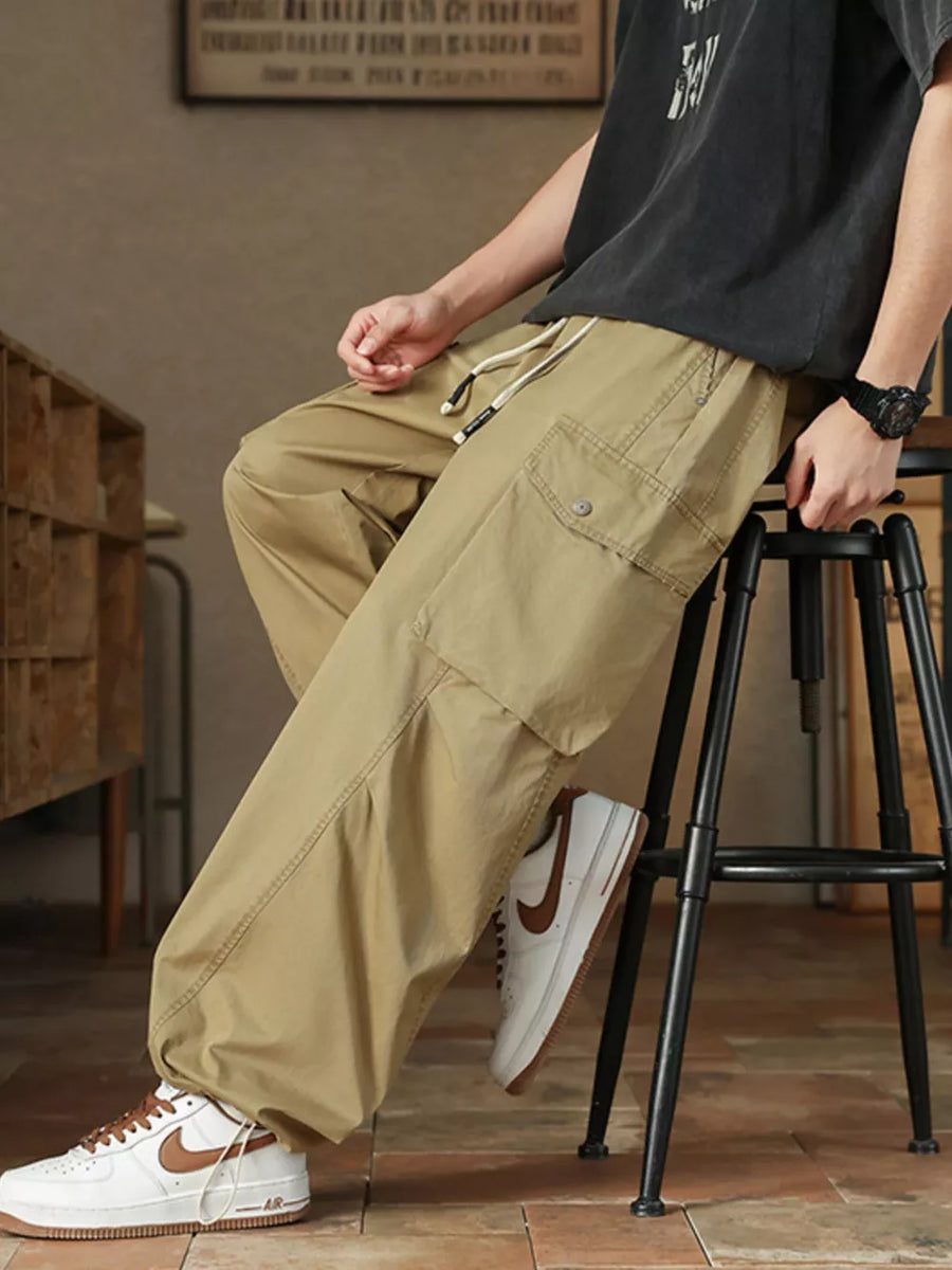 Khaki drawstring cargo pants for men with button-down flap pockets and adjustable waist.