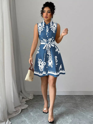 Dusty blue a-line dress with white print, button-down, tie waist, and ruching detail.