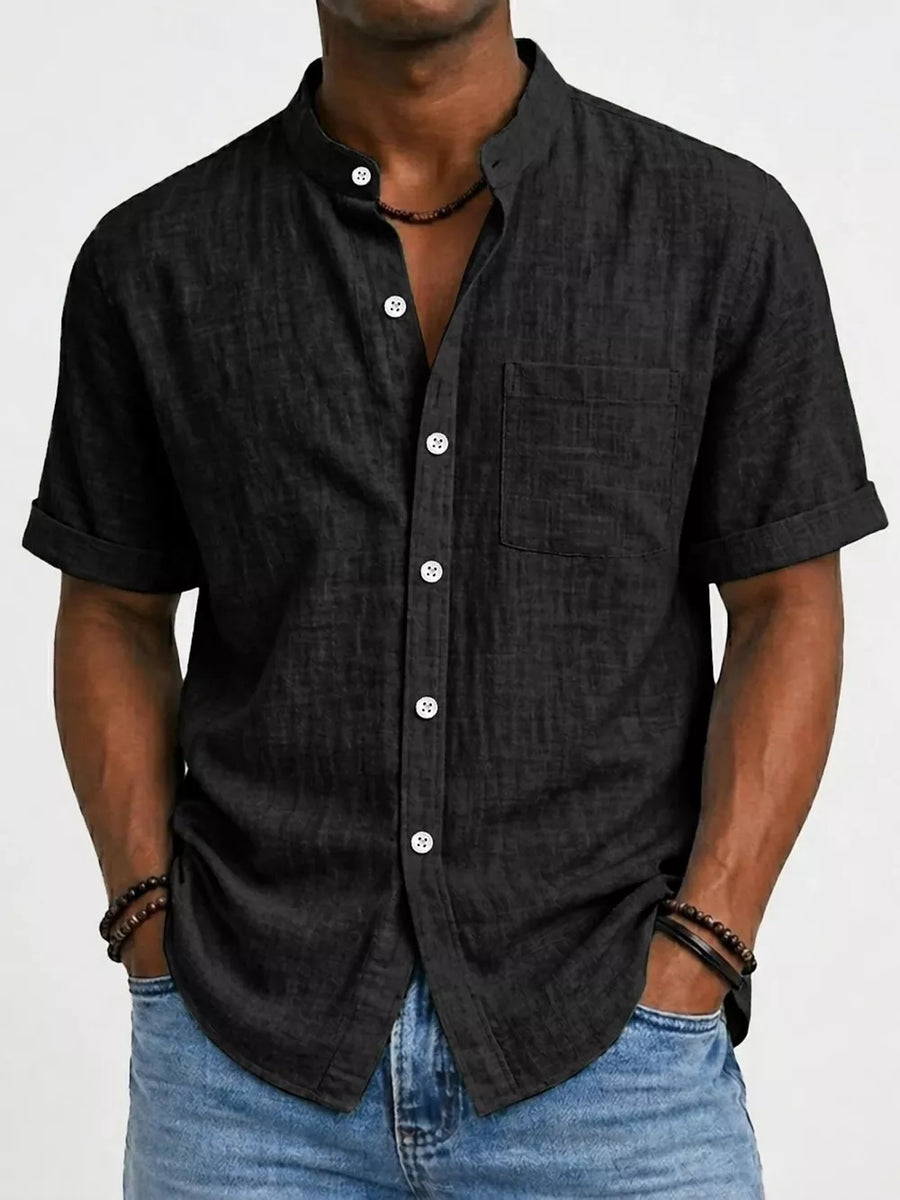 Black textured band collar button-up shirt with rolled short sleeves and chest pocket.