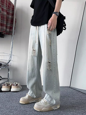 Oversized light blue distressed wide-leg jeans with drawstring waist.