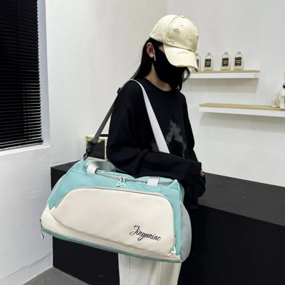 Medium waterproof duffel bag in light green and cream with pockets and embroidered text.