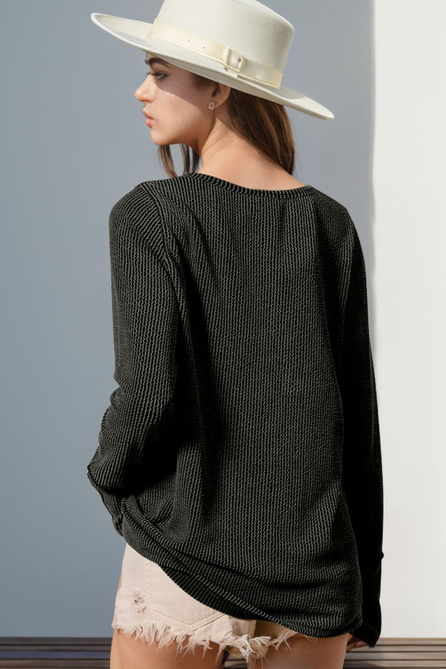 Black waffle knit henley shirt with thumbhole cuffs and a relaxed fit.