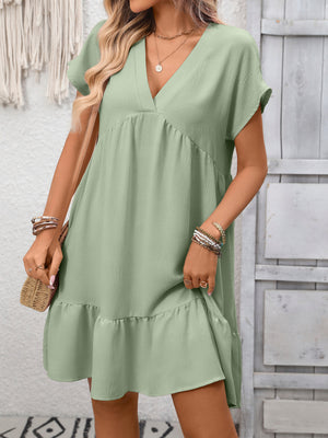 V-neck mini dress in Bean Green with short sleeves and ruffle hem.