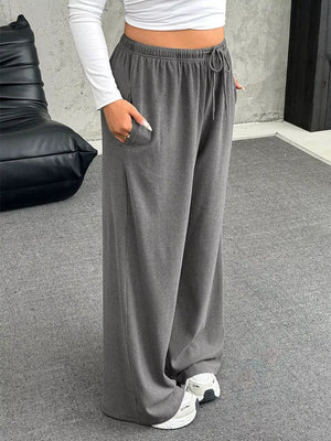 Gray drawstring wide-leg maternity pants with pockets and a relaxed fit.