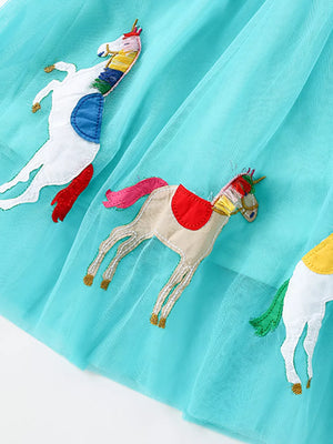 Aqua tulle baby dress with embroidered unicorns and colorful details.