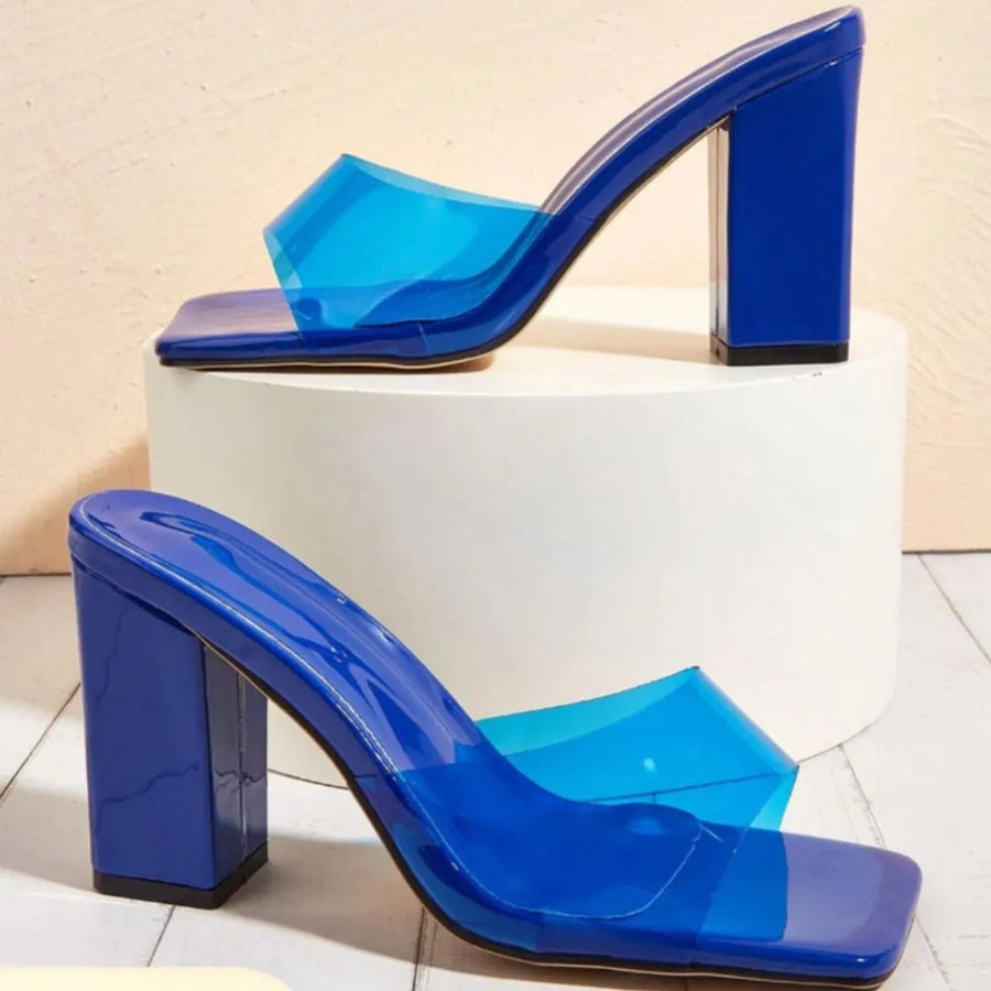 Blue lucite heel mules with clear strap and block heel.