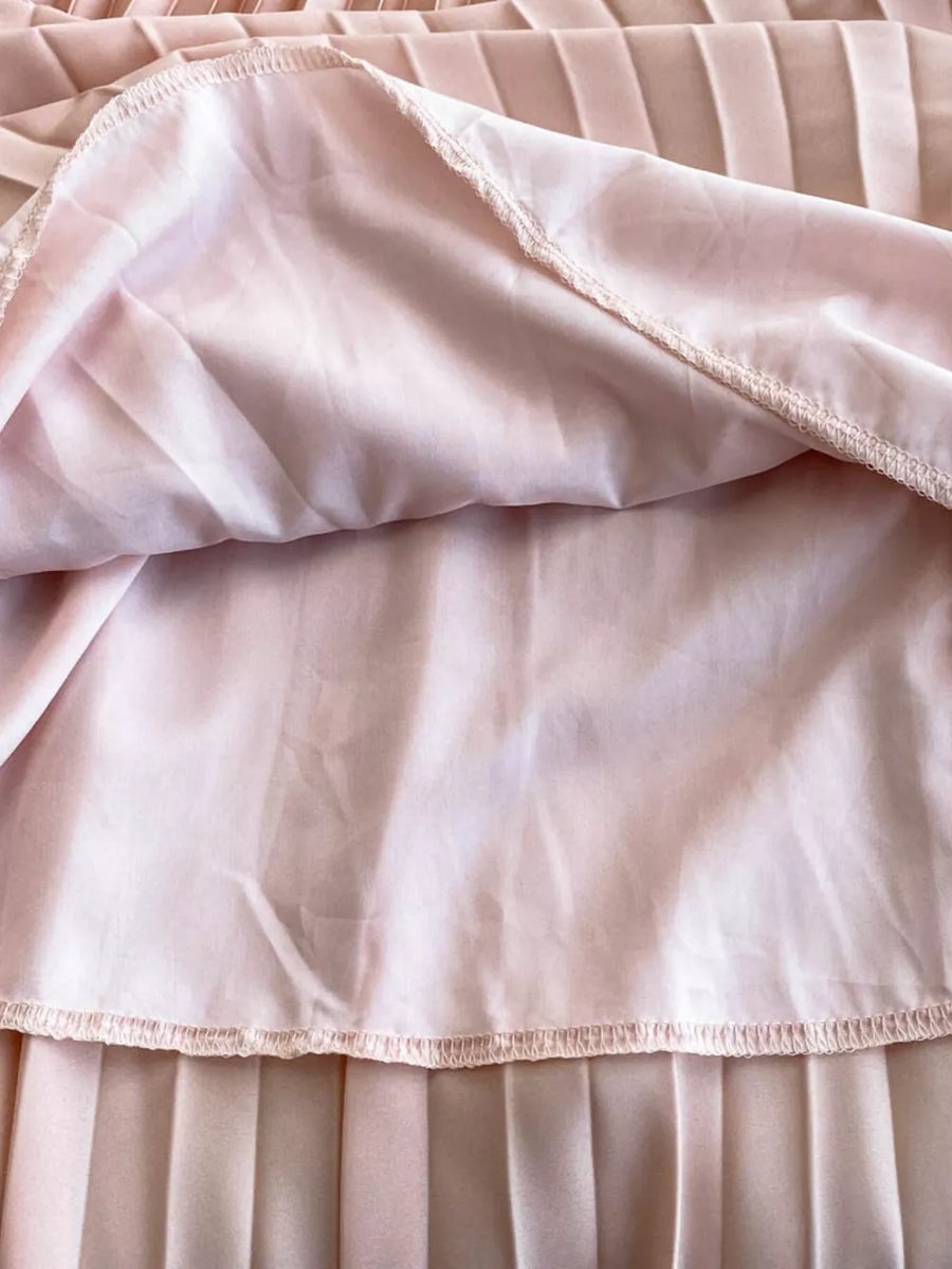 Pink pleated maxi dress detail showing lining and hem