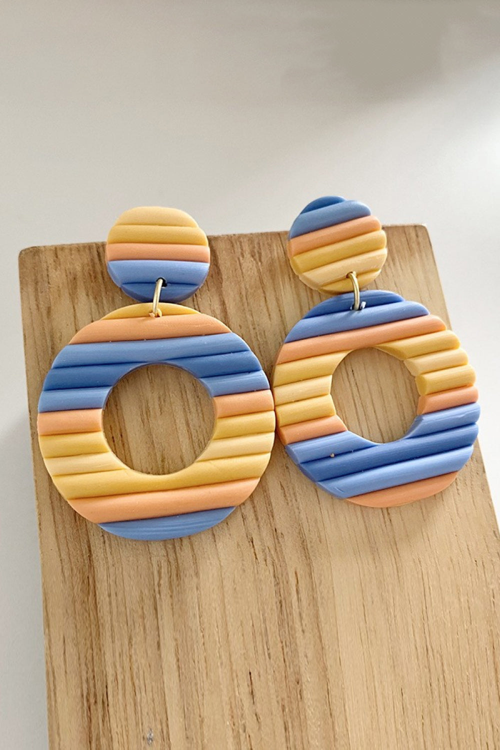 Textured hoop earrings with horizontal stripes in multicolor, aqua, lavender, and tangerine.
