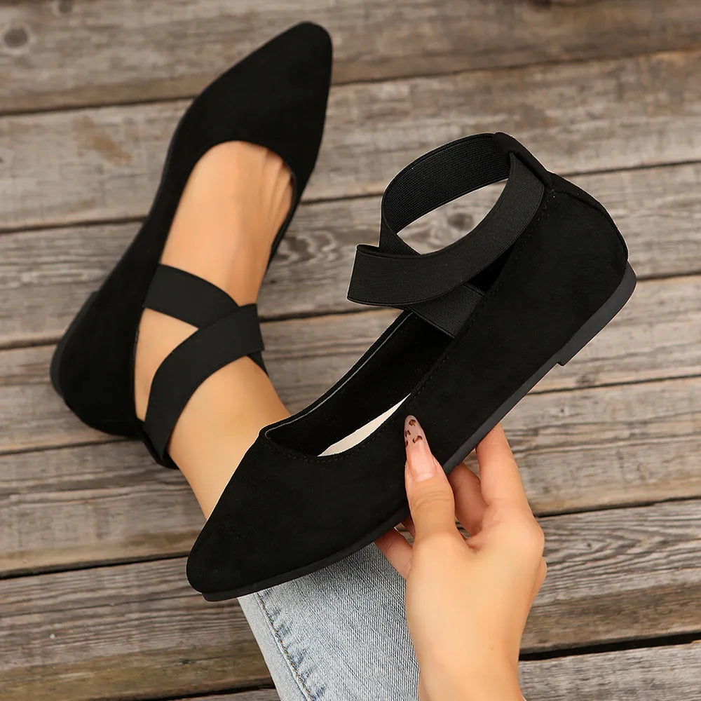 Black crisscross strap pointed-toe ballet flats with elastic ankle strap.