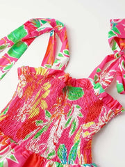 Tropical tie-strap smocked midi dress in strawberry pink with floral print and ruffled neckline.