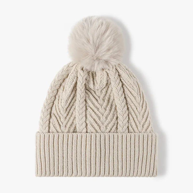 Beige chevron knit pom beanie with ribbed cuff and cable knit details.