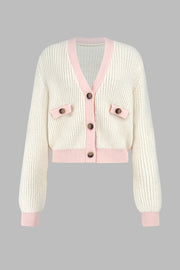 Cream cropped knit cardigan with pink trim and buttoned pockets