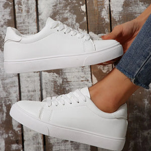 White leather-look platform sneakers with lace-up closure and round toe.