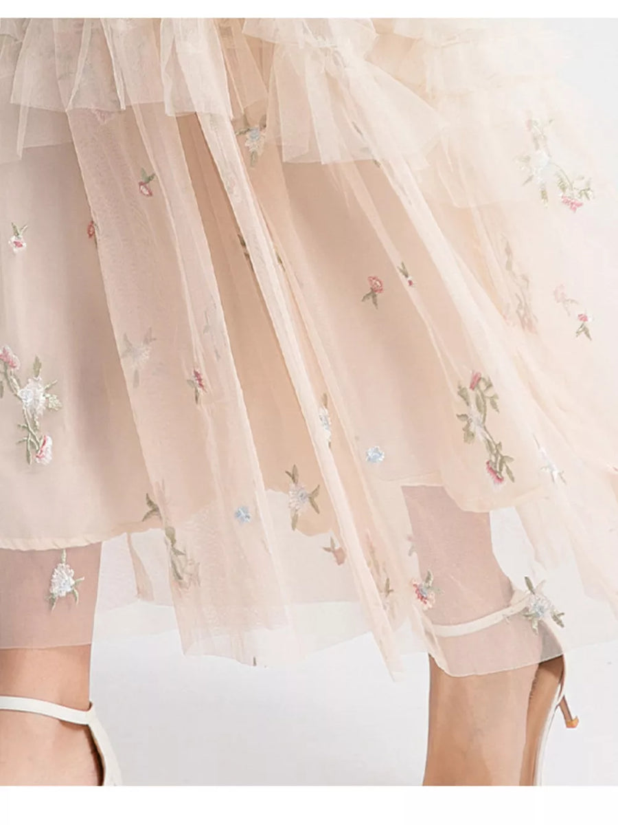 Embroidered floral tulle maxi gown with ruffled layers in a soft blush hue.