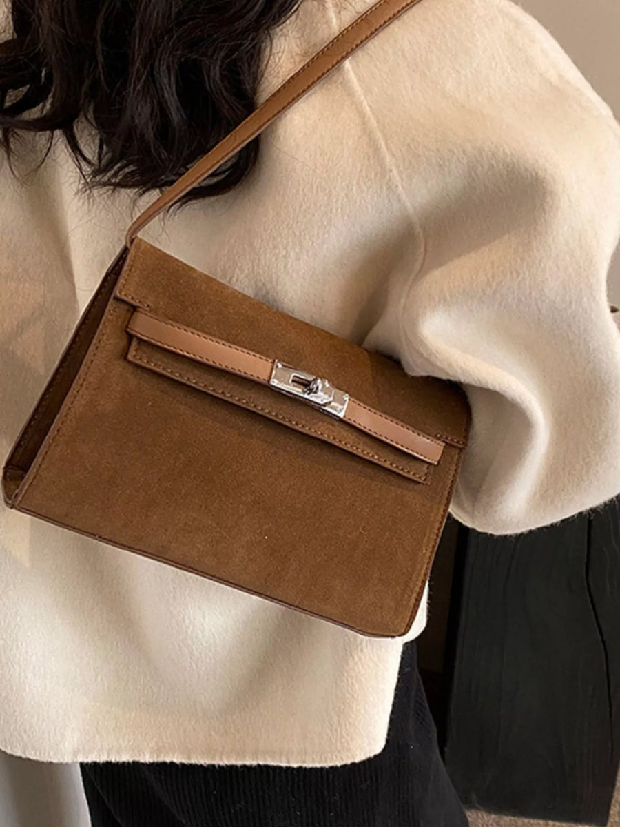 Brown suede shoulder bag with a silver buckle closure and tan leather trim.