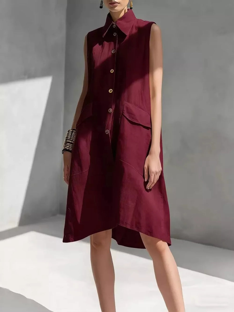 Sleeveless burgundy linen shirt dress with collar, button front, and patch pockets.