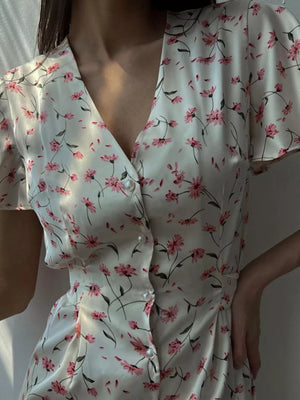 Floral print satin dress with v-neck, short sleeves, and pearl button front.
