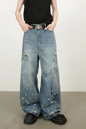 Distressed palazzo jeans in medium wash denim with raw edge detail and ripped accents.