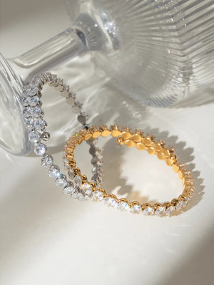 Double row pavé bangle bracelets in silver and gold with clear cubic zirconia stones.