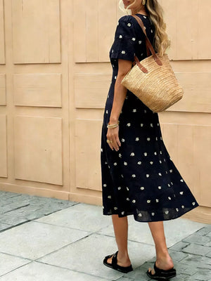 Navy blue midi dress with daisy print and tie-front detail.