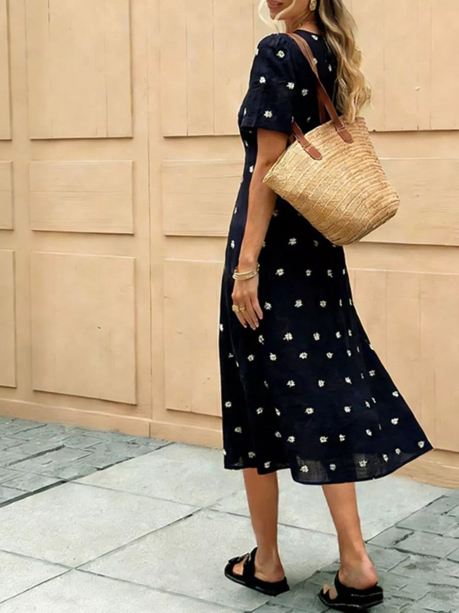 Navy blue midi dress with daisy print and tie-front detail.