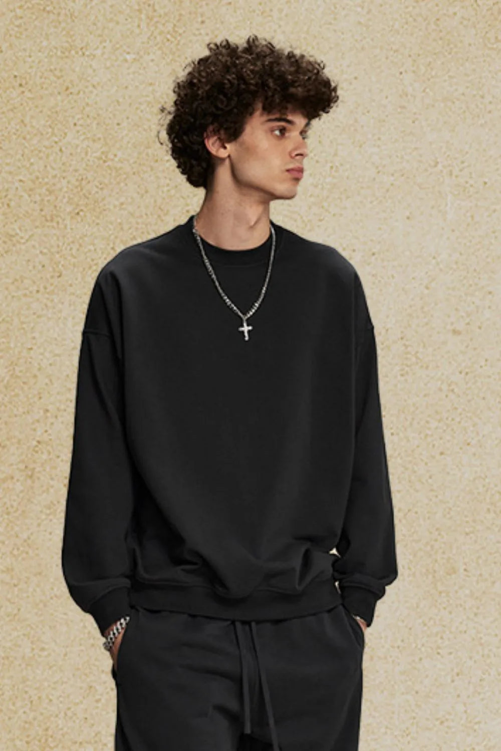 Black oversized crewneck sweatshirt with subtle shoulders and crew neckline.