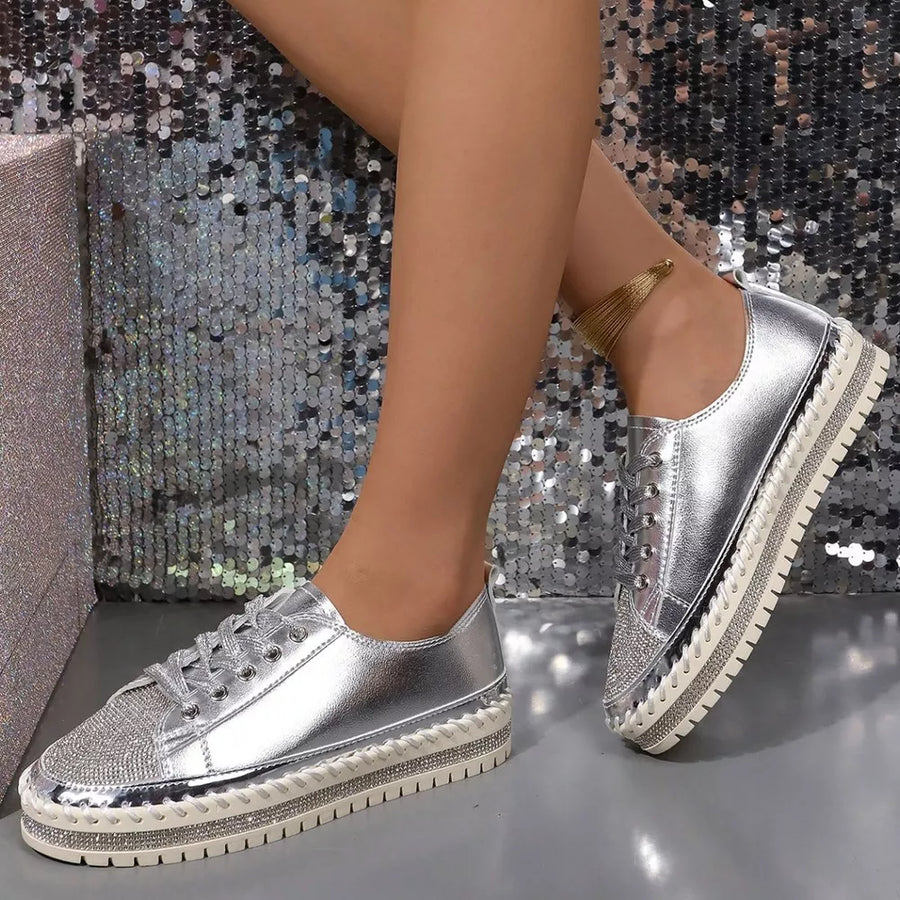 Silver sneakers with rhinestone toe and chunky sole.