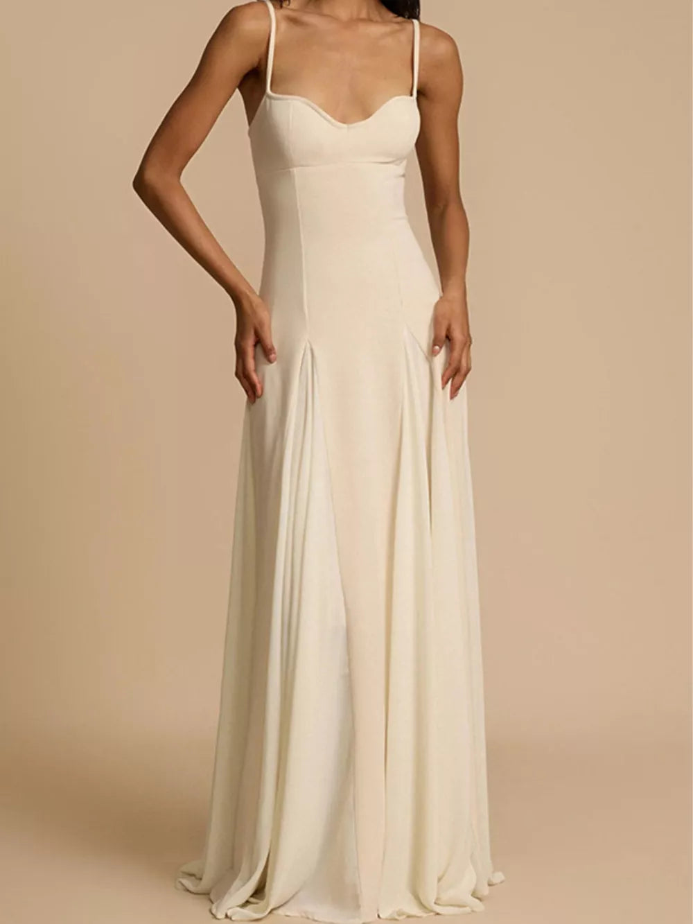 Elegant ivory sweetheart neck maxi dress with spaghetti straps and flowing skirt.