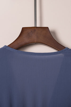 Dusty blue V-neck mini dress with subtle vertical texture and ruffled bow detail.