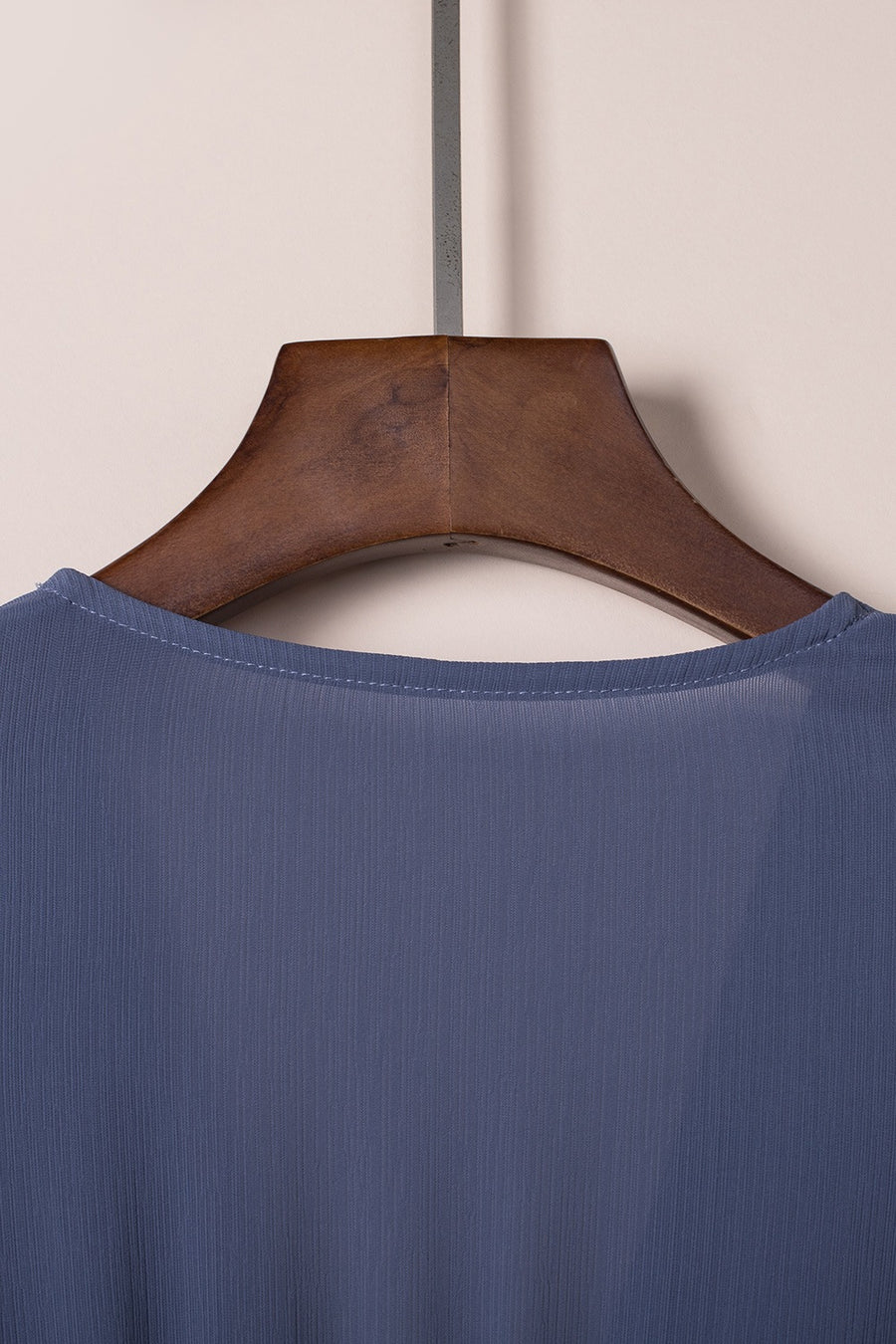 Dusty blue V-neck mini dress with subtle vertical texture and ruffled bow detail.