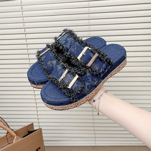 Denim fringe platform slides in navy with double buckles and a cork sole.