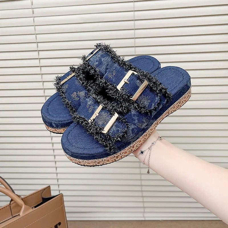 Denim fringe platform slides in navy with double buckles and a cork sole.