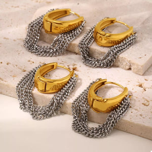 Chunky gold hoop earrings with layered silver chains.