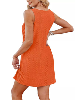 Orange eyelet tank dress with twisted hem detail and a textured pattern.