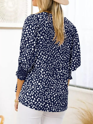 Navy blue animal print blouse with smocked half sleeves and a round neckline.