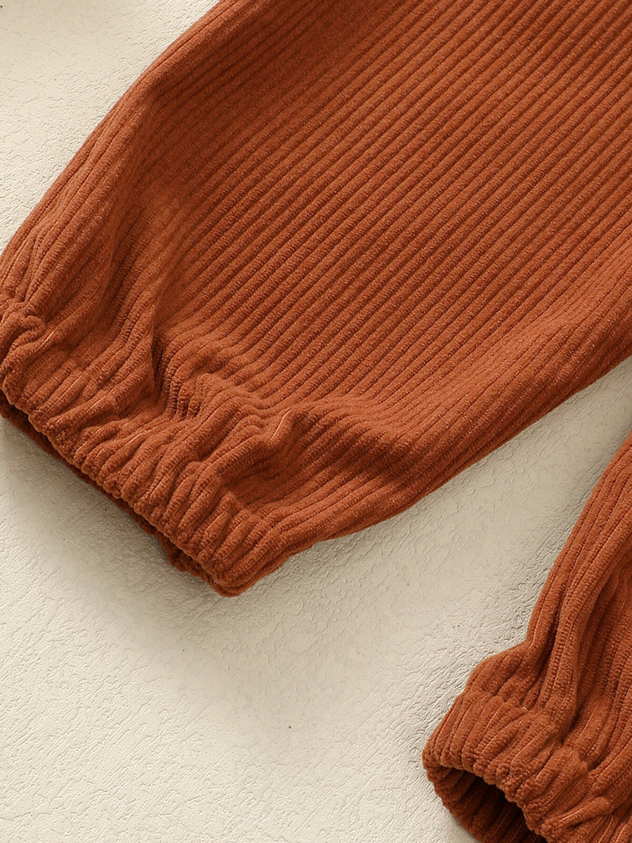 Kids brown corduroy overalls with elasticated cuffs and adjustable straps detail.