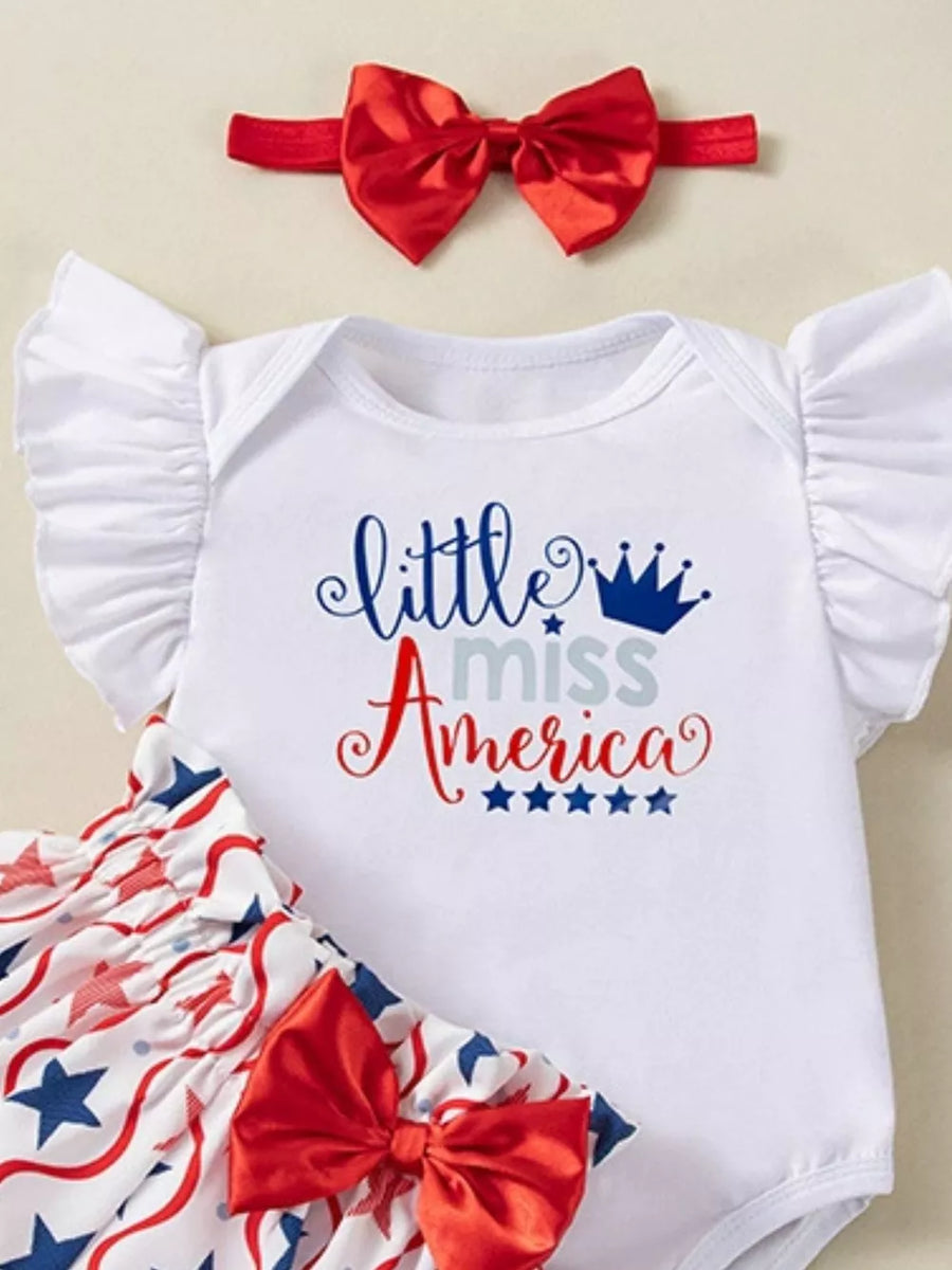 White baby onesie with "little miss America" graphic, ruffled sleeves, star print bloomer shorts, and red bow headband.