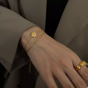 Gold double layered titanium steel bracelet with charm detail