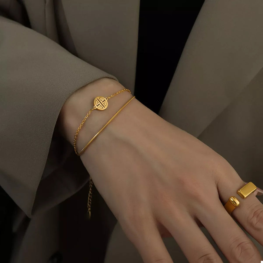 Gold double layered titanium steel bracelet with charm detail
