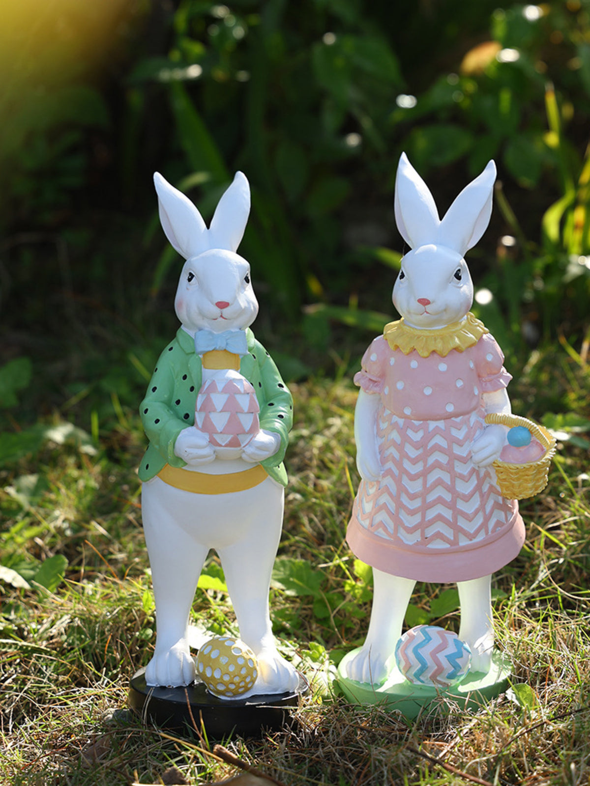 Easter bunny figurines in pink and green, holding decorated eggs and a basket.