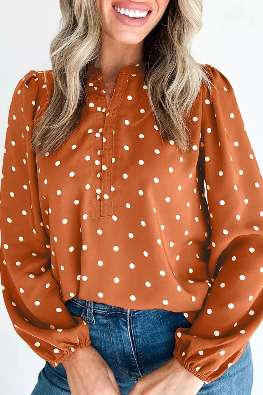 Charming polka dot V-neck shirt with button detail and long sleeves.
