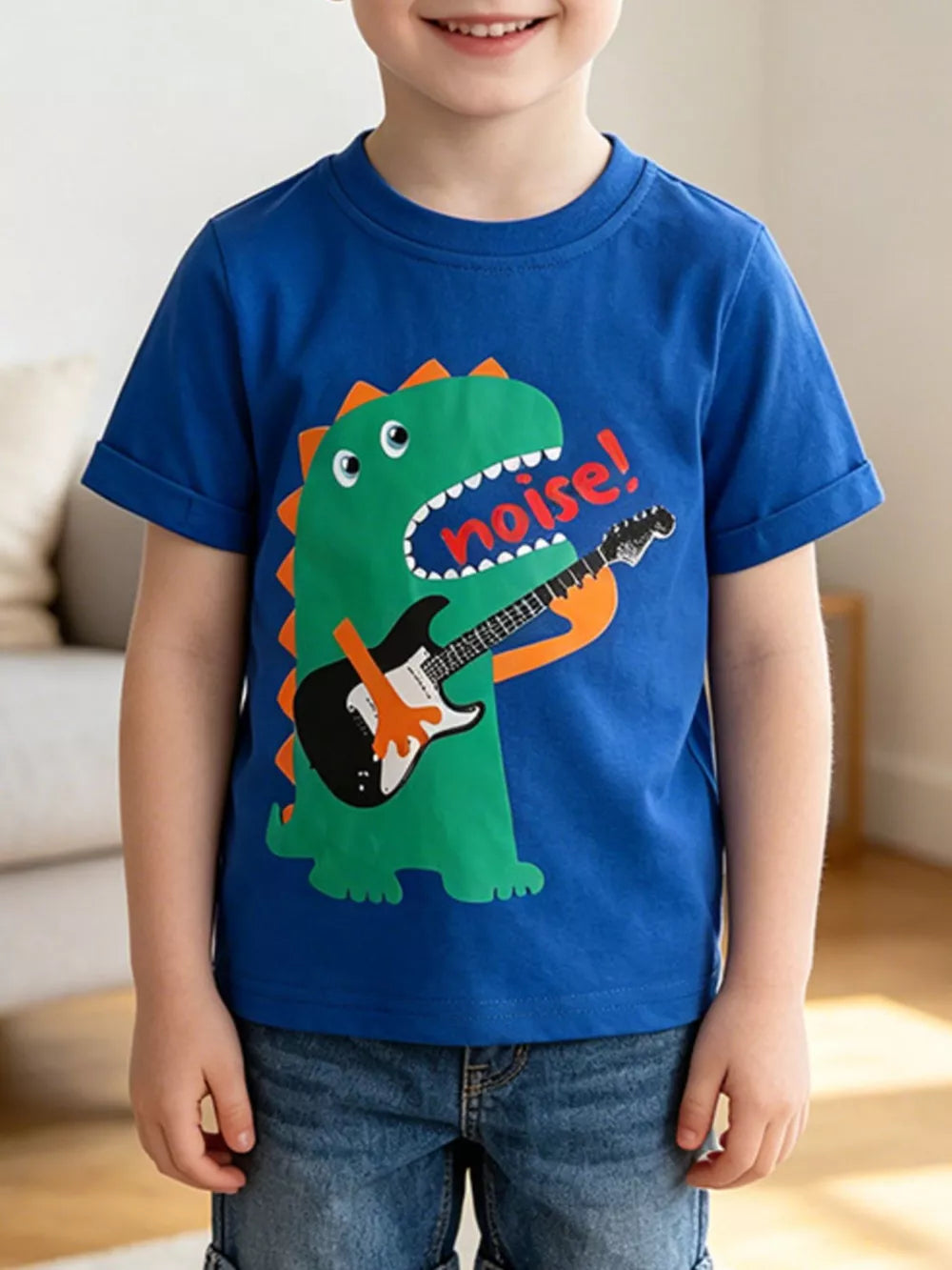 Blue cotton crew neck t-shirt with a green dinosaur playing a guitar and saying "noise!