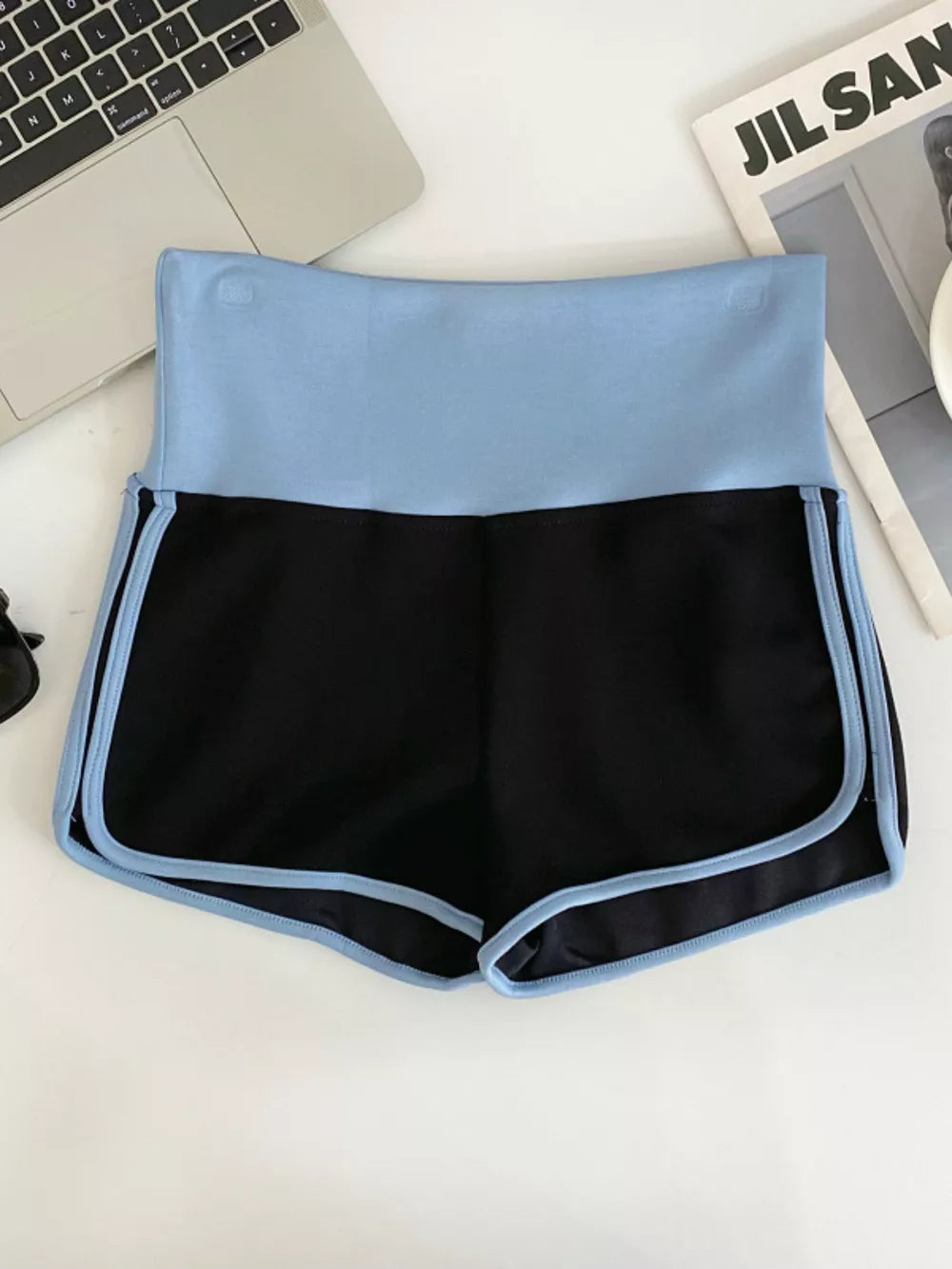 Black athletic shorts with light blue contrast trim and waistband.