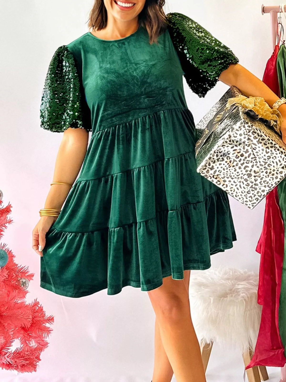 Dark green velvet tiered mini dress with sequin puff sleeves and round neckline.