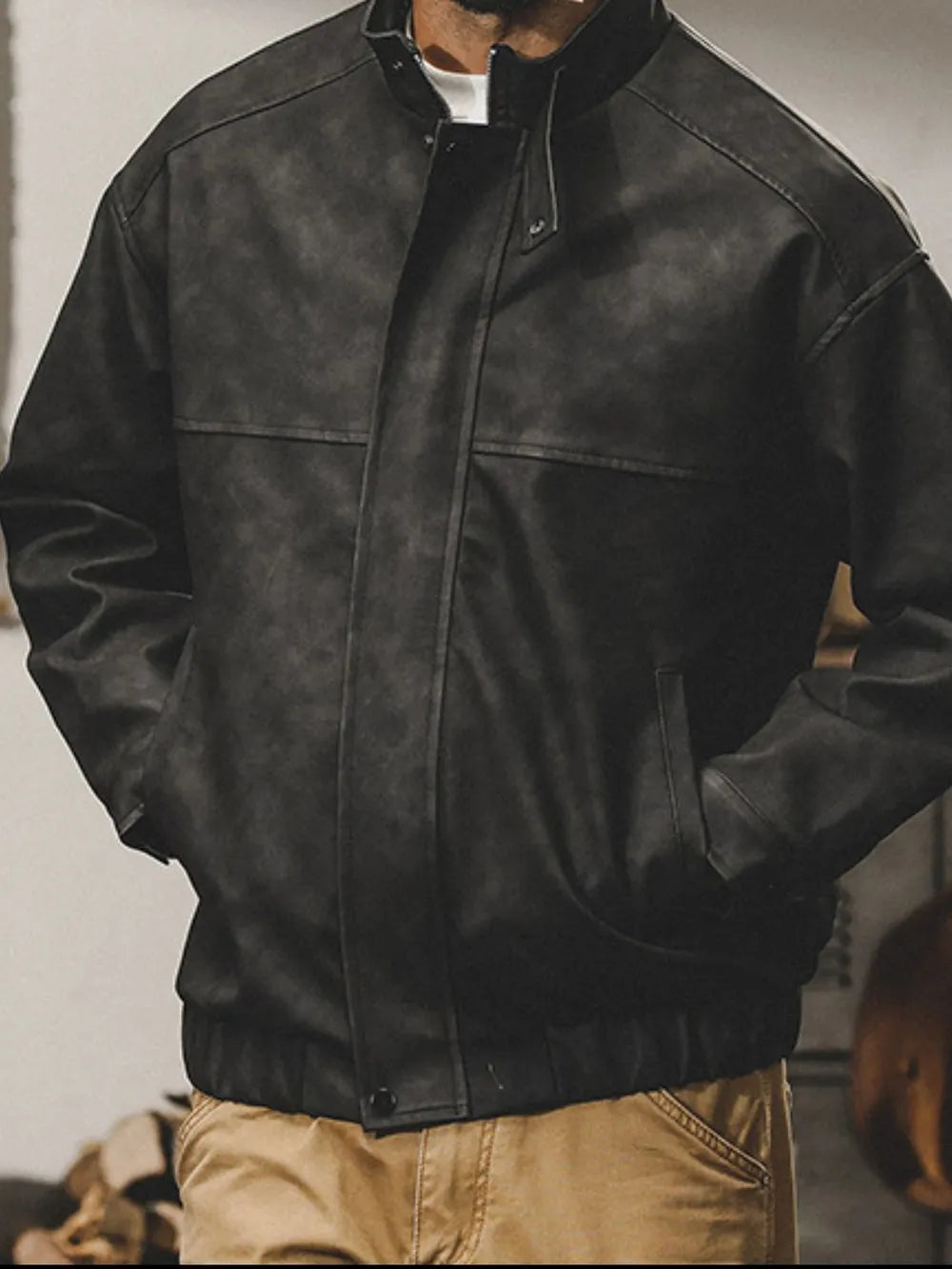 Distressed black leather bomber jacket with stand collar and elastic cuffs.