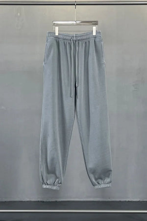 Gray relaxed fit drawstring sweatpants with elastic cuffs and side pockets.