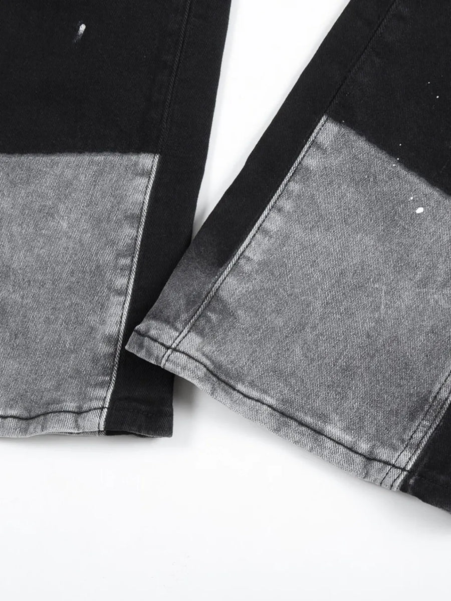 Split panel bootcut jeans in black and light gray with paint splatters.